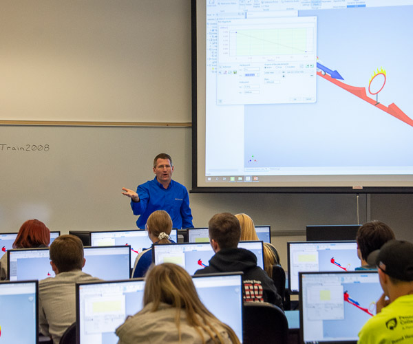 Craig A. Miller, instructor of engineering design technology, leads visitors to use computer aided design software to design, modify and test a virtual prototype of a new child’s toy to ensure it functions properly. 