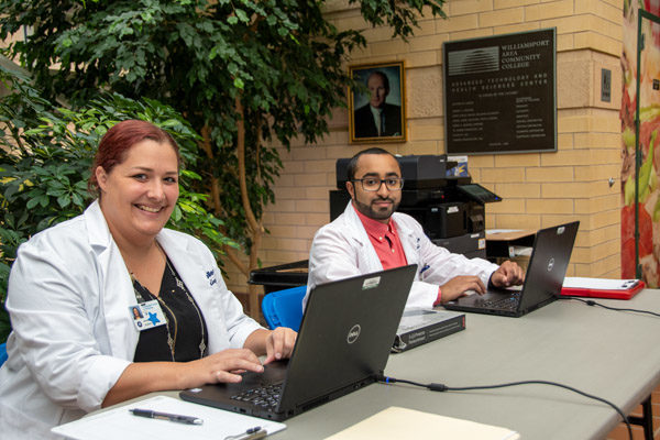 Amelia Buffington and Mohanad Alquraish prepare workstations for students to take a quick, anonymous mental health assessment.