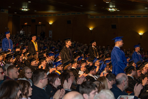 Servicemen and women in the fall Class of '19 stand for acknowledgement from a thankful audience.