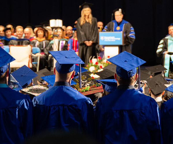 Graduates rise to turn their tassels.