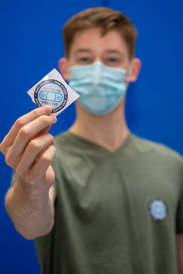 Showing off a vaccine sticker is Taylor J. Elliott, a welding and fabrication engineering technology major from State College. 