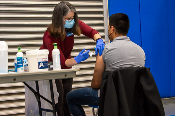 Kendra F. Boell, physician assistant instructor, administers a vaccine to Miguel A. Callado, a construction management student residing in Williamsport. 