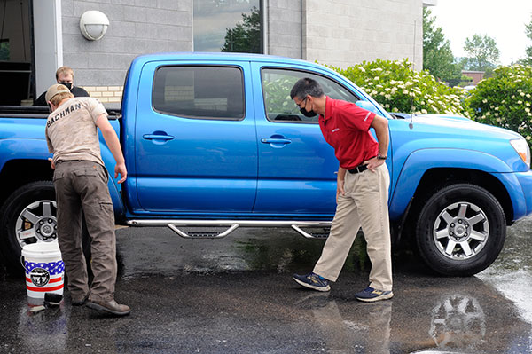 Taking advantage of a beautiful late-spring day – and espousing the notion that no job is too small to be done right – instructor Joe A. Tavani (in red shirt) schooled Automotive Technology participants in the showroom-quality method of washing a vehicle. 