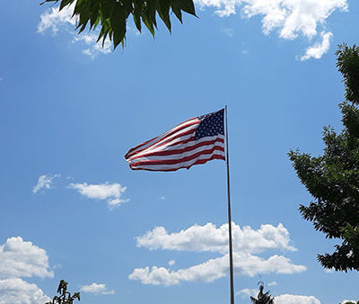 Blue skies and campus greenery frame "Old Glory," the focal point for Monday's community Flag Day celebration outside the SASC.
