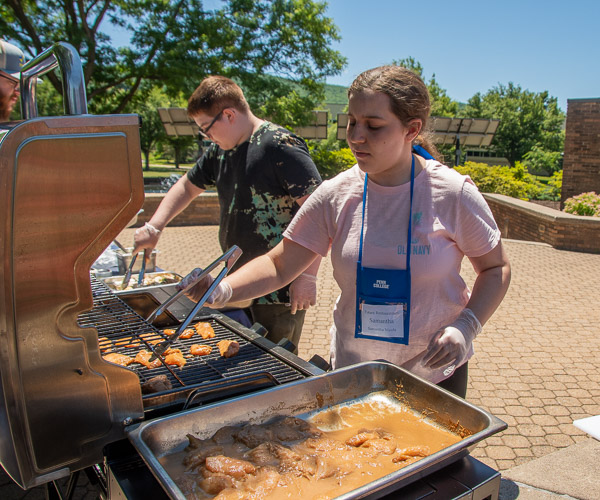 Campers grill chicken and corn on the cob as volunteers during a demonstration by Chef Christopher R. Grove, executive chef of Le Jeune Chef Restaurant.