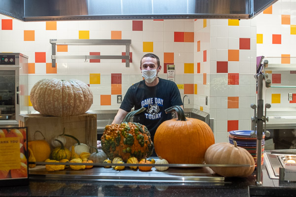 A Capitol Eatery pumpkin display, supplied by John L. Carpenter Jr., a student in plastics and polymer engineering technology, frames the friendly face of Dining Services Leader Dave C. Munro during Breakfast With the President. Carpenter’s family owns Carpenter’s Farm in Linden.