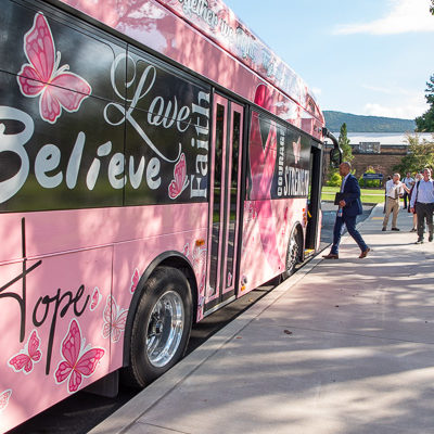 Williamsport Mayor Derek Slaughter boards a River Valley Transit bus – promoting breast-cancer awareness, one of several commemorative buses in the city's fleet – for a levee tour. 