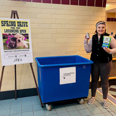 Lacey A. Decker, a dental hygiene student and information desk assistant in the Bush Campus Center, shows off the collection bin and some of the items already contributed. (Photo – and those inaugural donations! – courtesy of Shannon L. Skaluba, student organization specialist)