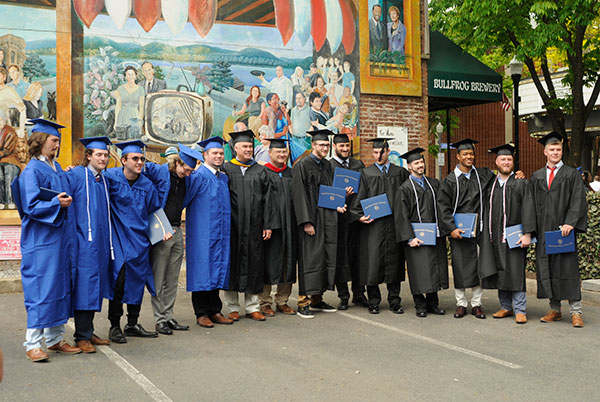 Two- and four-year aviation graduates gather with faculty mentors across West Fourth Street from the commencement venue.