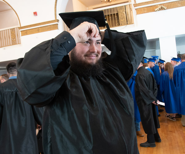 Colton M.E. Long, an electronics & computer engineering technology grad from Northumberland, makes a final adjustment to his cap.