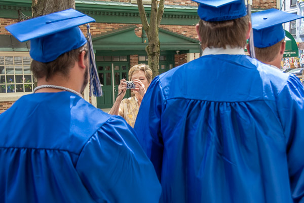 During a pause in the procession, a fan captures a photo of her favorite grads.