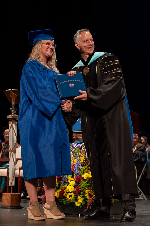 The distinction of being the final graduate in the new president's first commencement goes to Tiffani Amber Traugher, surgical technology.