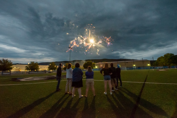 Convocation presenters watch the fireworks display at the center of the field.