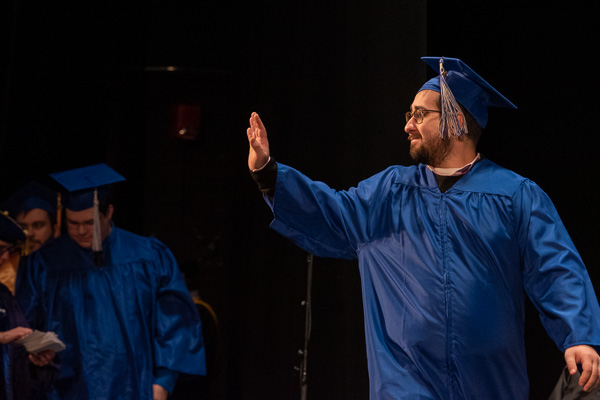 Welding alum Connor C. Kleckner waves to the loved ones cheering him on.