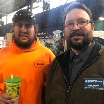 Reuniting at the college's display area are Tyler W. Dunn (left), a 2018 graduate of the college's heavy construction equipment technology: operator emphasis major, and Justin W. Beishline, assistant dean of diesel technology and natural resources.