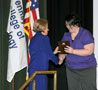 Luke is awarded a plaque by Sara R. Hillis, assistant director of student activities for student services and involvement