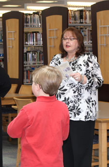 Lynne H. Koskie, library acquisitions manager, previews upcoming events during the exhibit's Feb. 13 opening reception. (Photo by Michael S. Fischer, student photographer)