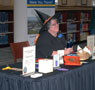 Librarian Rhonda A. Fisher dons a witch's hat to accept registrants for door prizes