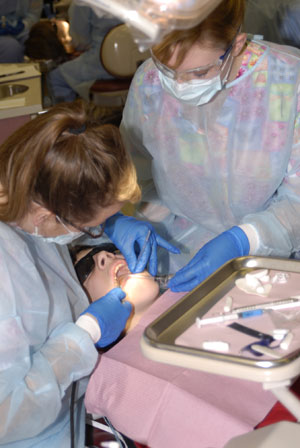 Kelly L. Shively, of York, a dental hygiene student (left), and Sharon J. Sagl, of Schnecksville, a student enrolled in the dental hygiene%3A health policy and administration concentration major, apply sealants to a participant in the recent %E2%80%9CSealant Saturday%E2%80%9D event at Pennsylvania College of Technology%E2%80%99s dental hygiene clinic.