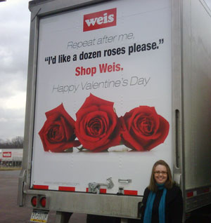 Trisha (Corey) Herrick stands by a Weis Markets truck that carries one of her Valentine's Day teasers.