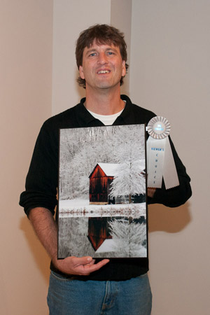 Michael A. Dreese, of Kreamer, holds 'Winter Mirror,' which captured the Viewers%E2%80%99 Choice award in an art exhibition celebrating the talents of alumni of Pennsylvania College of Technology and its forerunners.