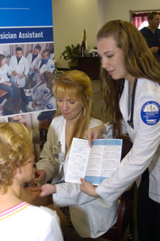 Kimberly M. Johnson, of Oak Ridge, Tenn., checks the blood-glucose level of Darlene Dunkleberger while Chelsea L. Chamberlin, of Northumberland, explains the assessment at a free diabetic education event at Medicap Pharmacy.