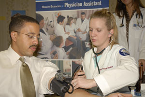 Assistant student Bethany K. Lavallee, of Jersey Shore, checks the blood pressure of Dr. Calvin B. Johnson, state secretary of health, at a grange health fair.