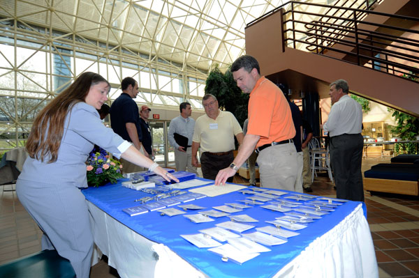 JoAnn M. Otto, Plastics Manufacturing Center secretary, helps registrants in the ATHS atrium, while Timothy E. Weston, plastics faculty member (white shirt at right), and students welcome other guests.