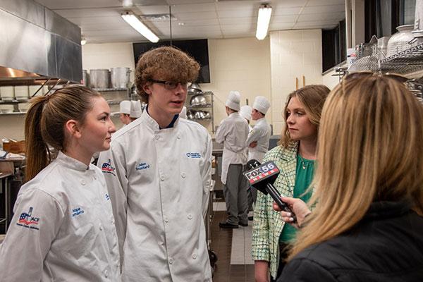 Whartnaby talks with Derby-bound students (from left) Hope G. LoMarro, of Exton, baking & pastry arts; Jalen J.L. Stunkard, of New Fairfield, Conn., baking & pastry arts; and Kylee P. Albert, of Boyertown, business administration.
