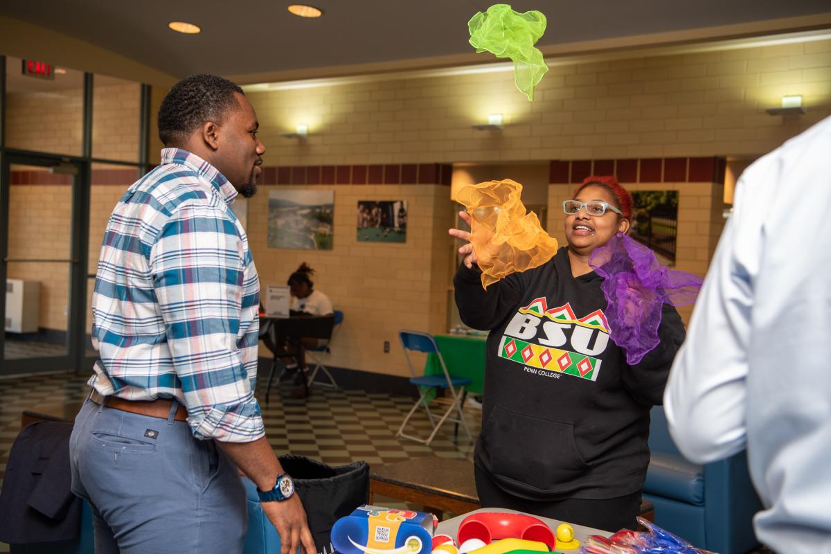 Woods encourages Monique C. Anderson-Parker, a human services & restorative justice student, as she tries her hand at juggling scarves. 