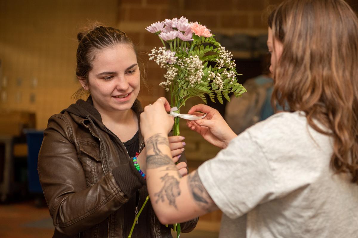 Radiating joy, Hayden Lester, business management, accepts a bouquet as forest technology student Kylie N. Butler adds a finishing touch. 