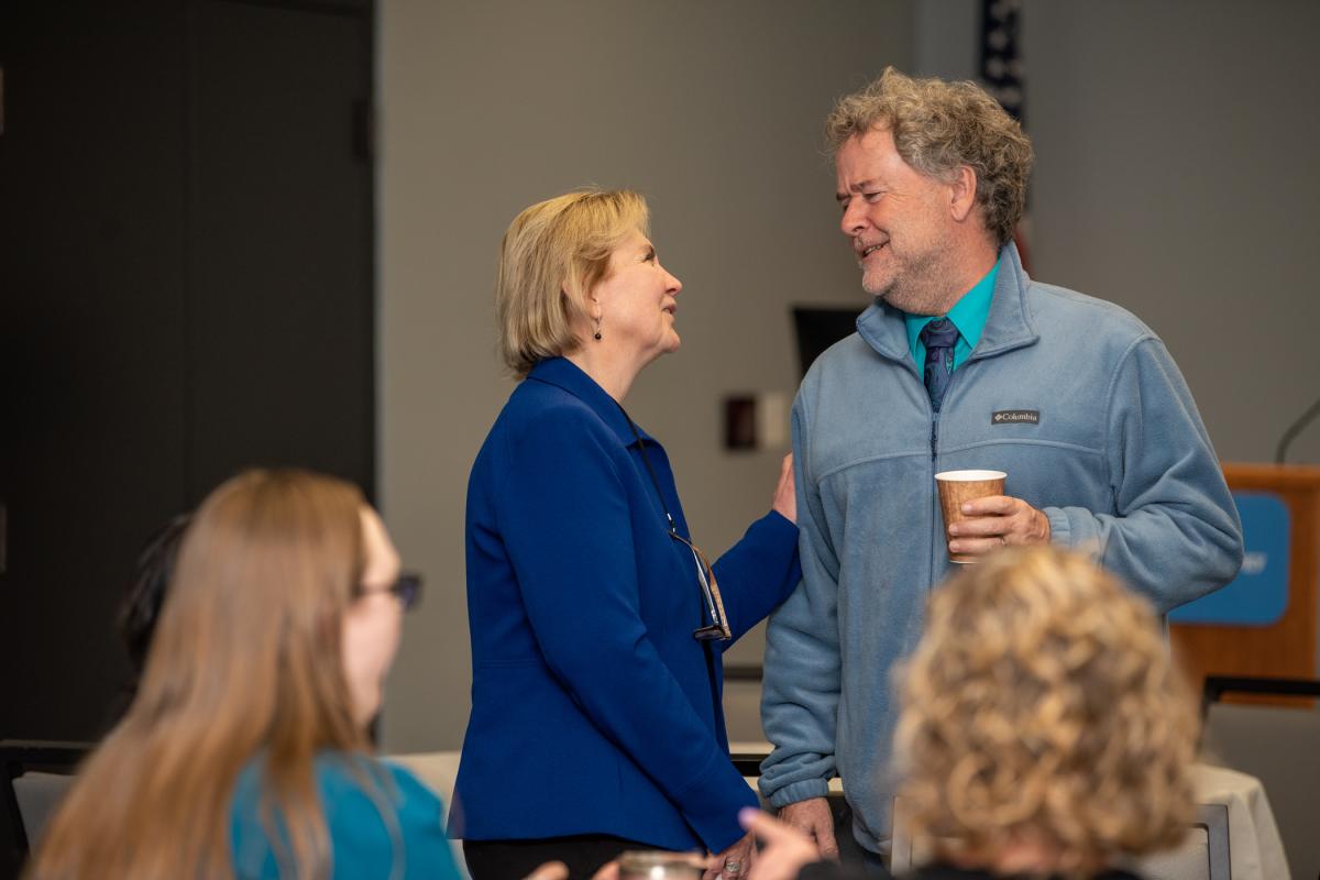 Alp enjoys chatting with Chip D. Baumgardner, associate professor of business administration/management.