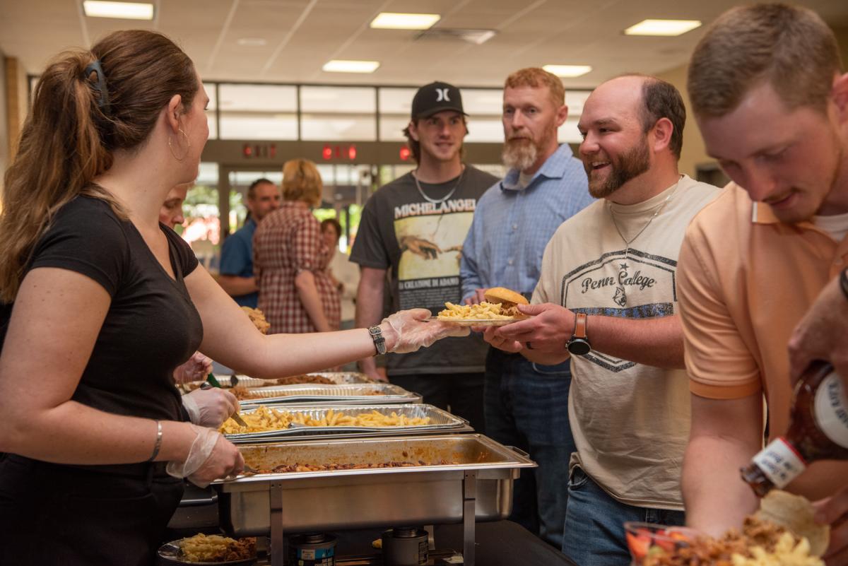 Rantz R. Mahaffey, external records evaluator in the Registrar's Office, happily accepts a plate from The Food Guy Catering Co.