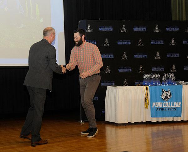 Lacrosse coach Jordan G. Williams (right) accepts congratulations from Scott E. Kennell, director of athletics, for his team's superior community service.
