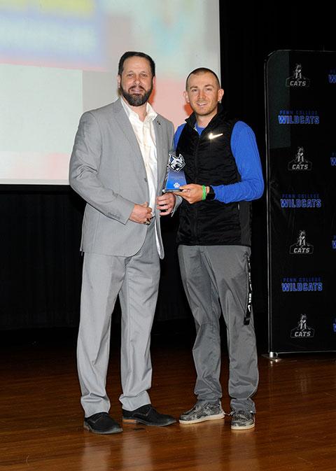 Matt J. Blymier (left), assistant director of athletics, presents Assistant Coach of the Year honors to Wildcat baseball's Devon M. Sanders.