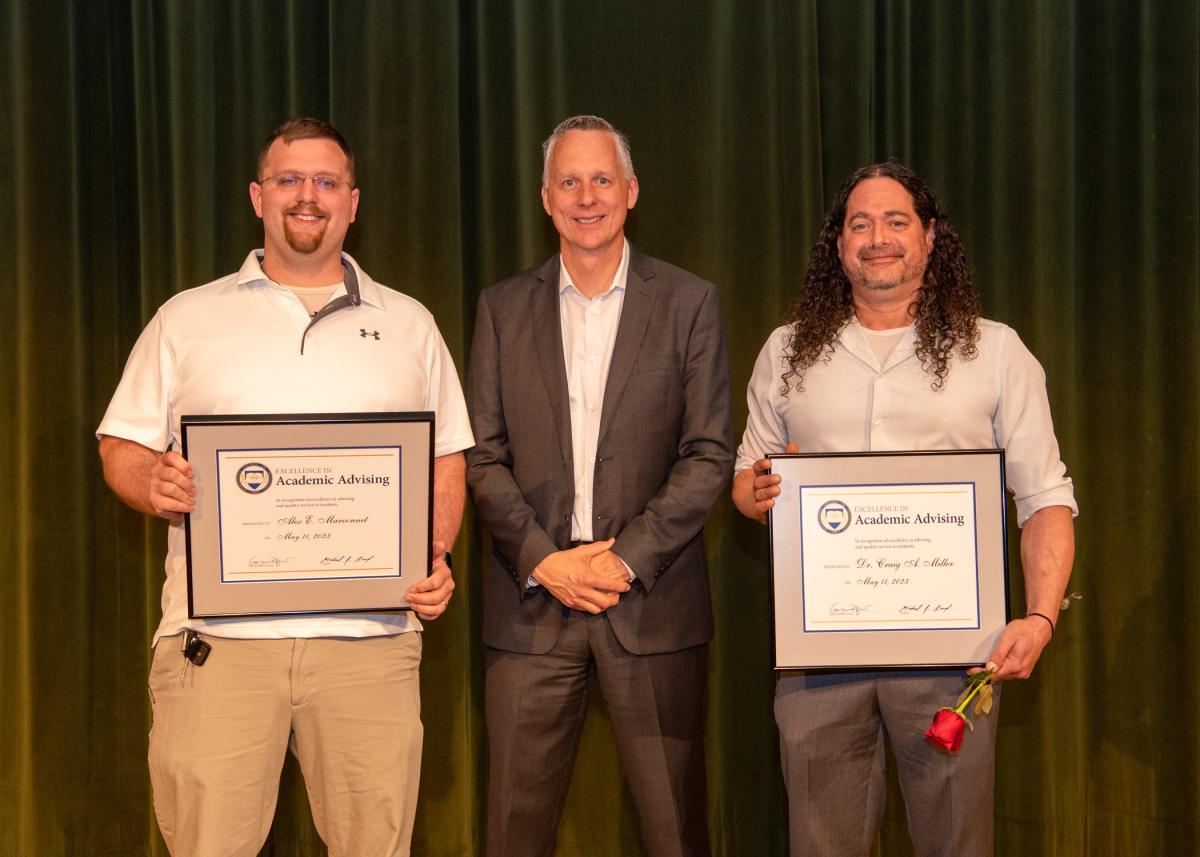 Excellence in Academic Advising Award recipients Alex E. Marconnet (left) and Craig A. Miller flank Reed.