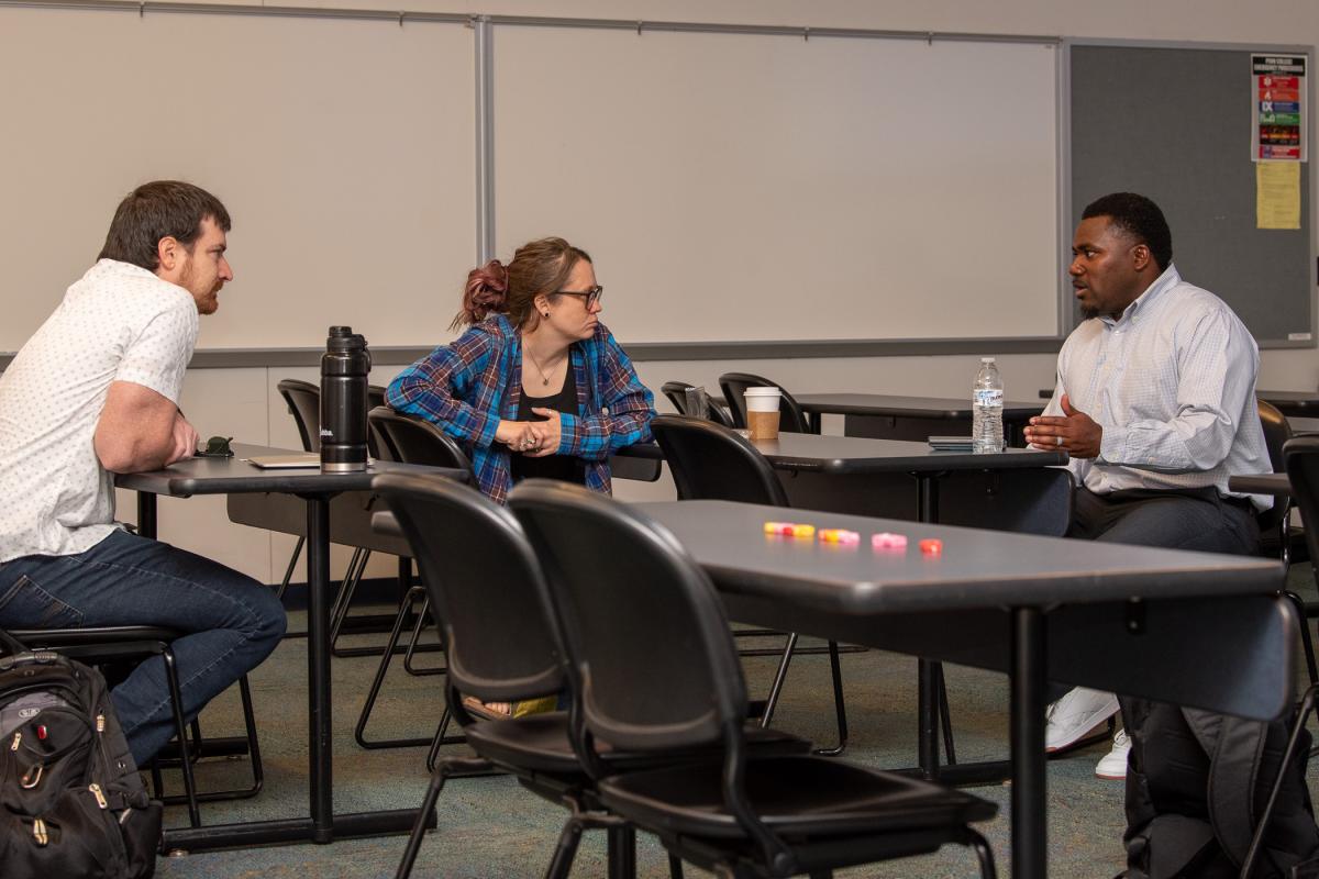 The schedule also provided opportunities for sidebar connections, like that being enjoyed by (from left) Christof Keebaugh, assistant professor of physics; Summer L. Bukeavich, associate professor of business administration/management and marketing; and Woods.