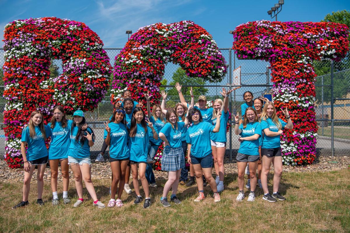 Celebrating on their final day of camp, the Tinker-Belles gather in front of a campus landmark.