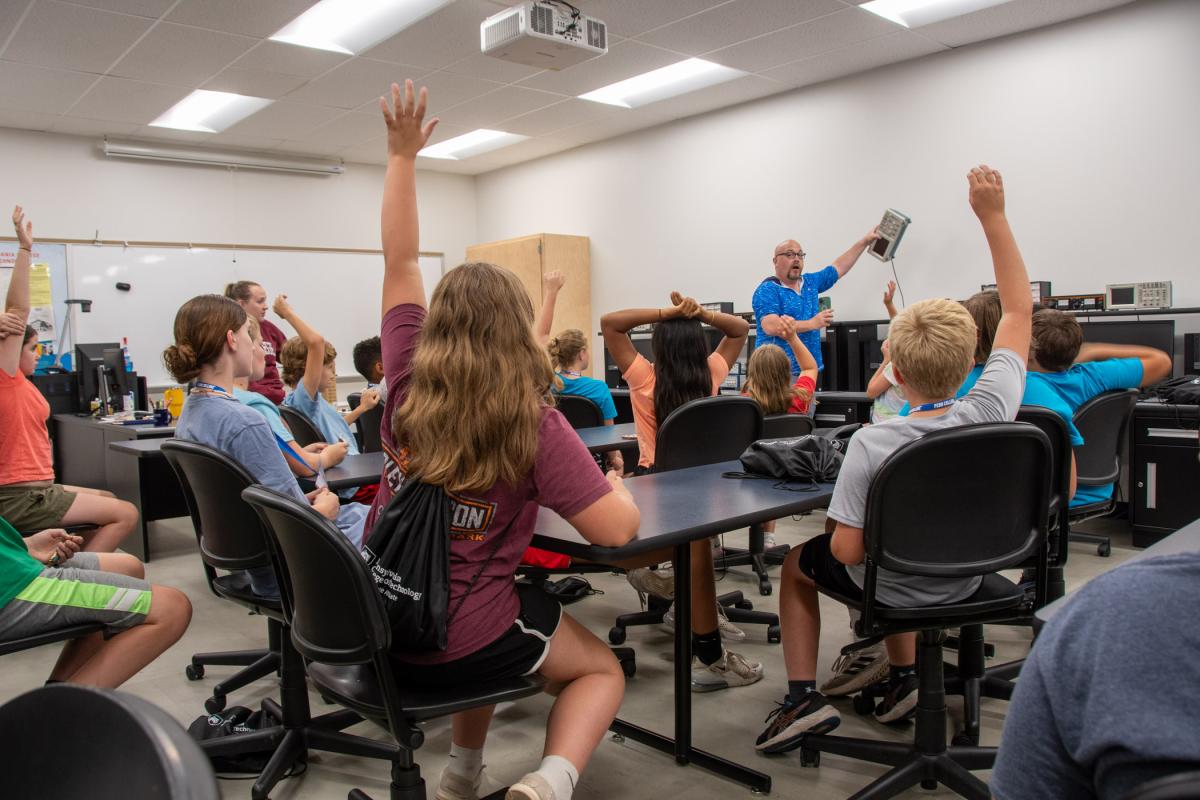 Participants eagerly vie to share what they know about electricity during a hands-on experience in the Electrical Technologies Center, provided by Eric L. Anstadt, instructor of electrical technology/occupations.