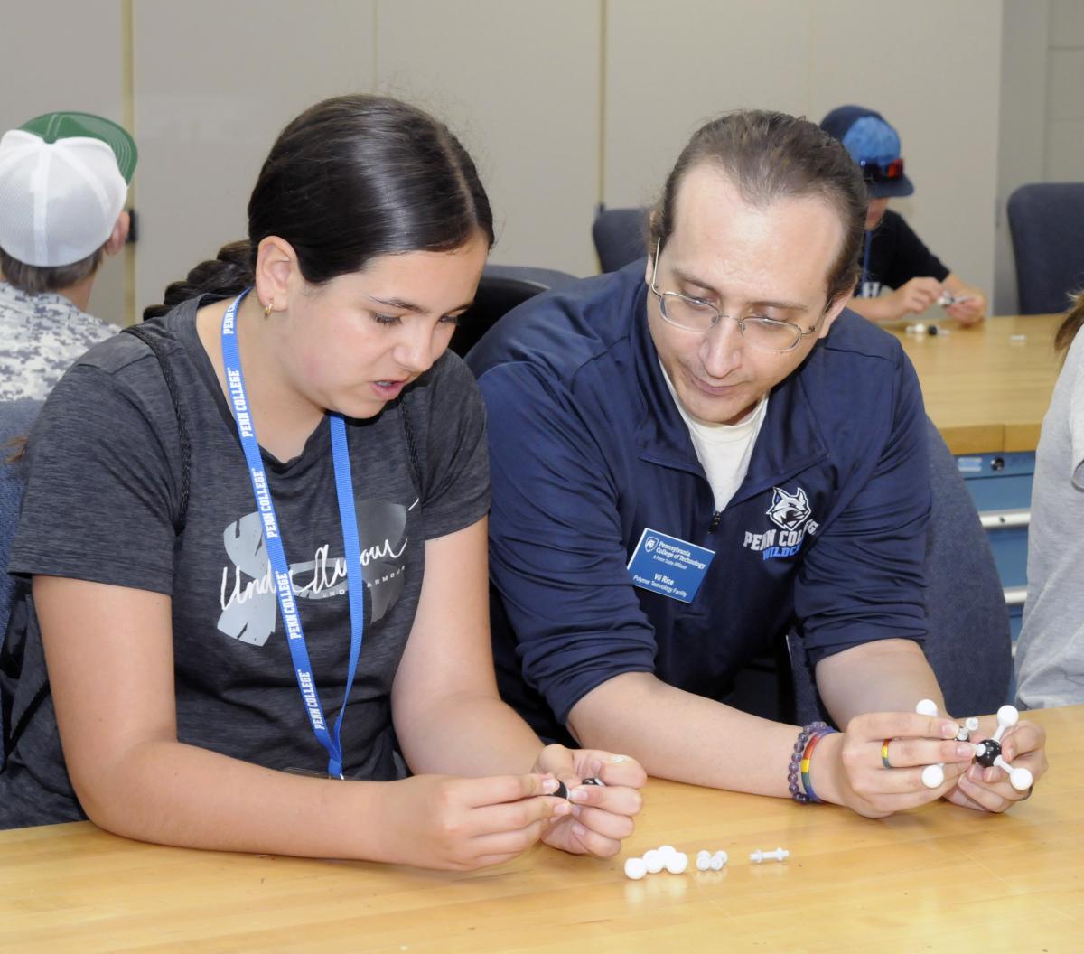 Vii J. Rice, instructor of plastics technology, watches a girl build a three-dimensional model of a hydrocarbon ...