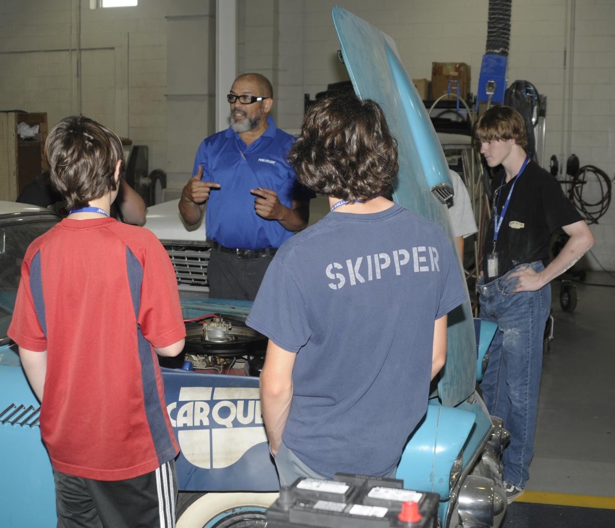 Youths get a unique tutorial on vehicle maintenance, as Pruden uses a vintage Ford Thunderbird as his example.