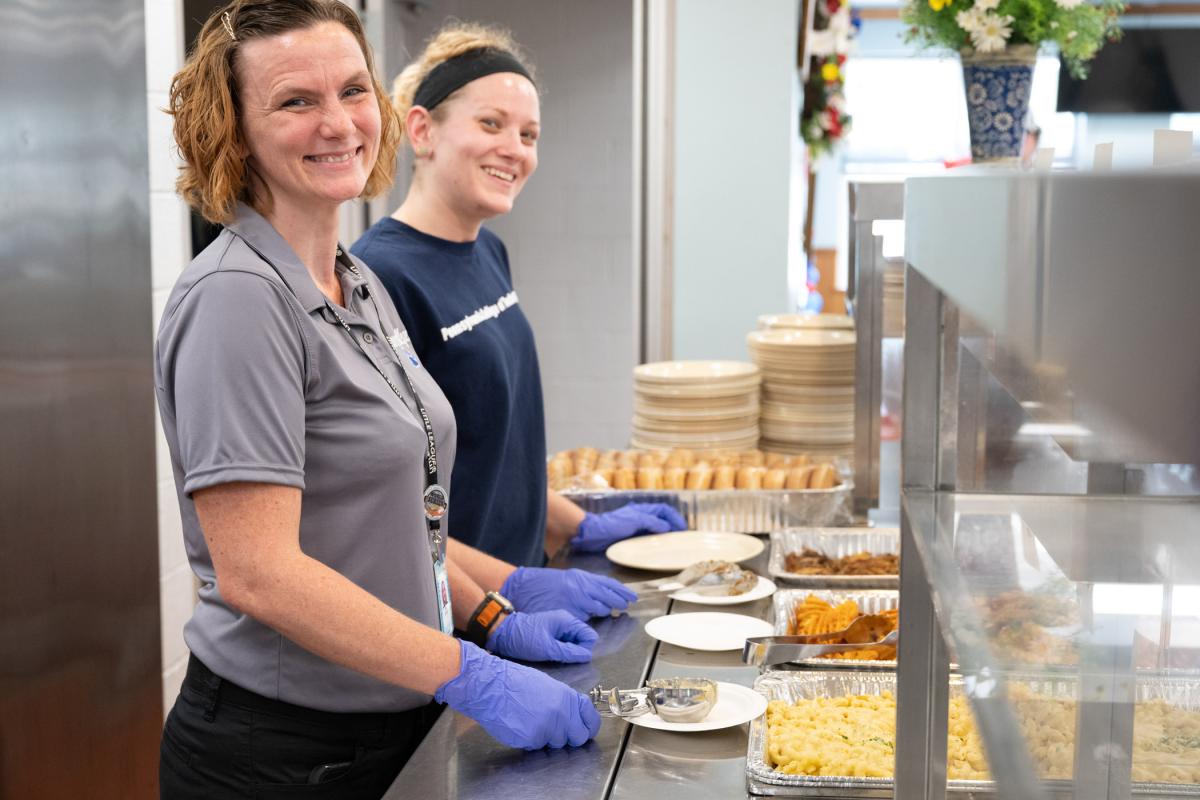 Penn College’s Johle (left) and Brittany L. Krape, food and hospitality/culinary arts storeroom attendant, stand ready to serve World Series players and coaches in the team dining hall at the Little League International complex.