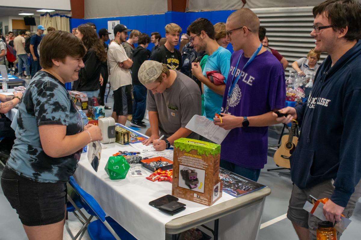 Gamers' Guild member Lily E. Day, of Lock Haven, happily engages with enthusiastic hobbyists stopping by their table. From Monopoly to Minecraft, Catan to Magic: the Gathering, the campus organization welcomes interested students to its games and meetings throughout the year.