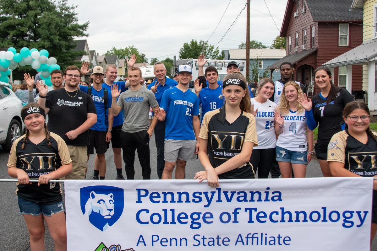 A portion of the Penn College parade contingent, joined by President Reed and the divisional banner carriers, indulges the photographer in the staging area.