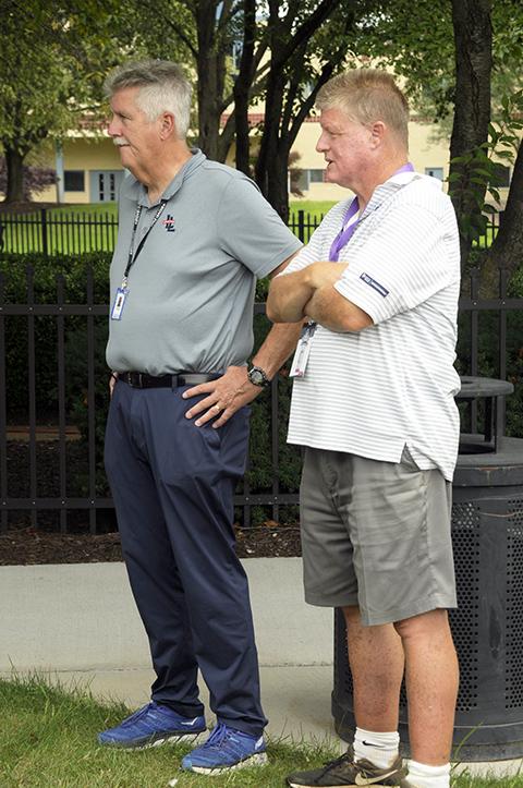 A pair of local sports dignitaries – Rob Thomas (left), a public address announcer for the Little League Baseball World Series (and the Williamsport Crosscutters), and Tom O'Malley, a locally raised former Major Leaguer – watches the teams' arrival.