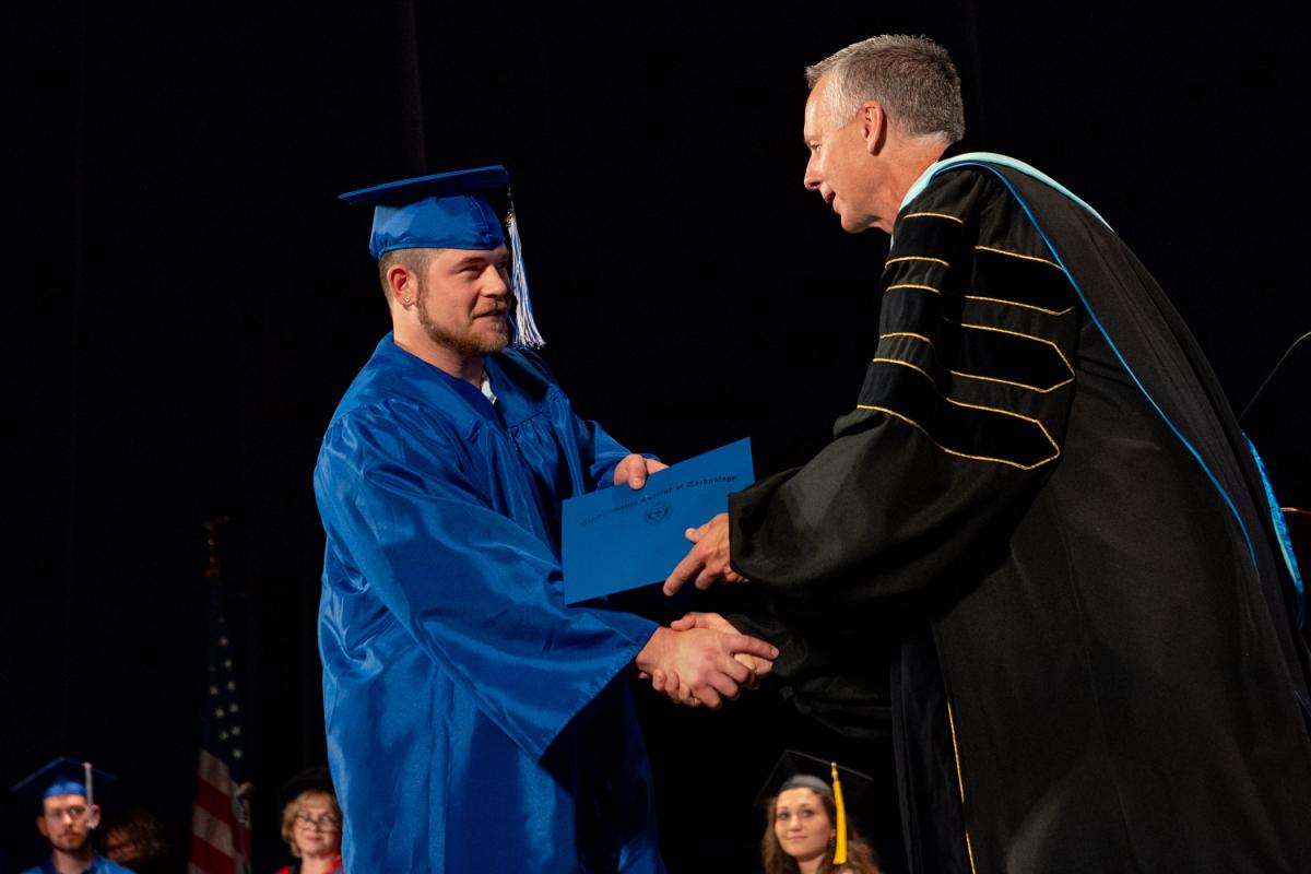 The significance of Peyton A. Biscoe's accomplishment, earning a two-year degree in diesel technology, clearly registers with on-stage onlookers. 