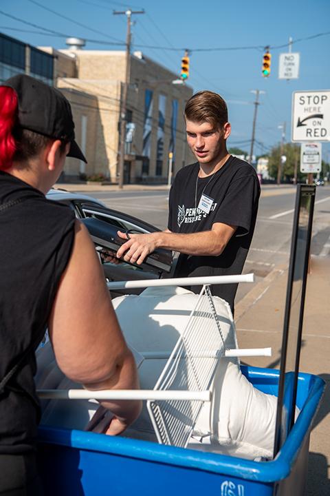 Outside The Village, RA Kaleb Dylan Styer, a collision repair technology student from Herndon, helps move items from car to bin ...