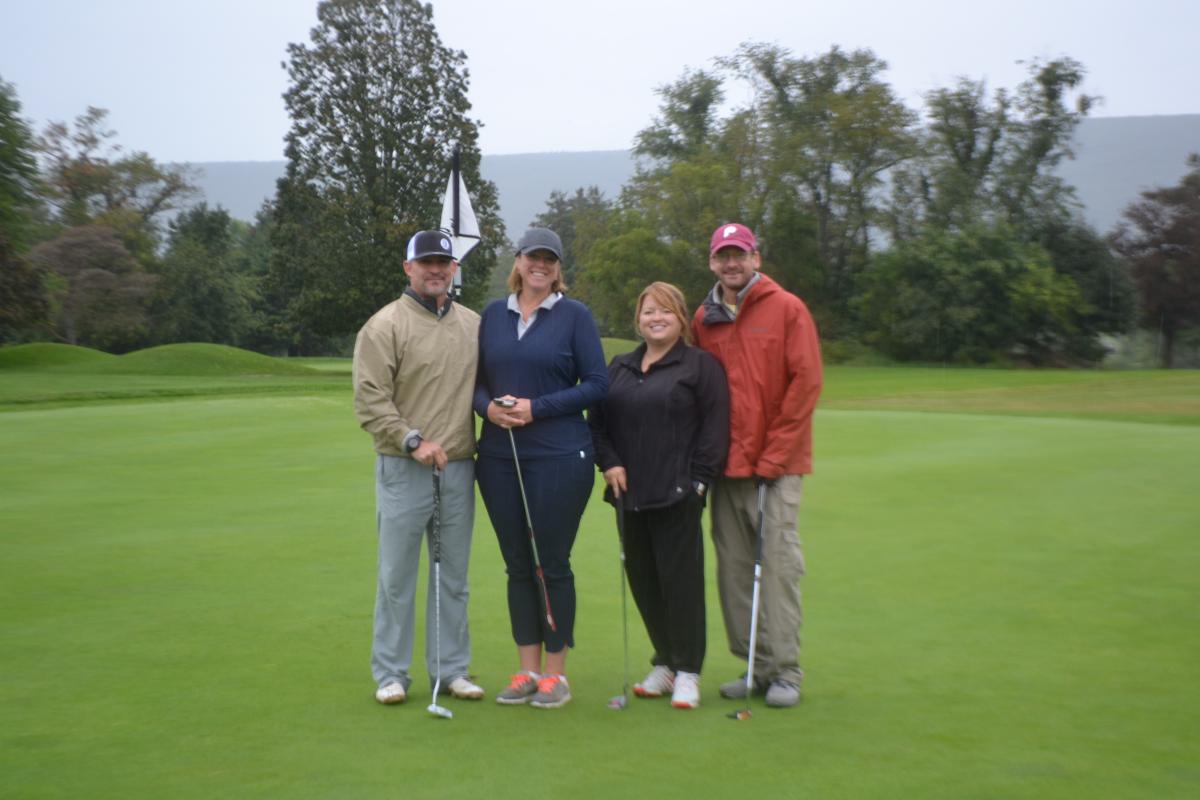 The green, green grass of White Deer attracts this group of golfers, obliging a photographer with winning smiles. Anchoring the quartet is John J. Heebner (in red jacket), whose three Penn College degrees include a 2005 bachelor's in construction management.