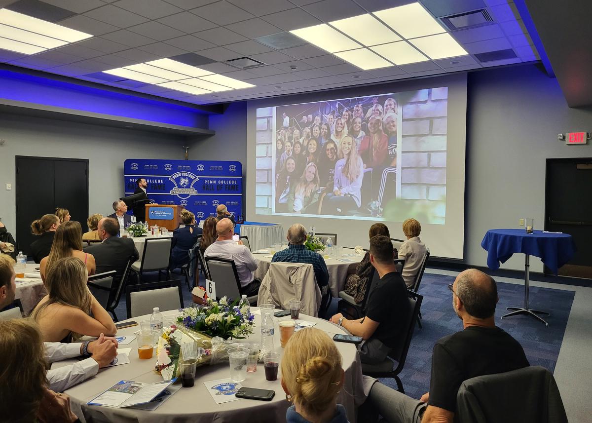 Emcee Matt J. Blymier (at podium), assistant director of athletics for compliance and athletic communication, introduces an on-screen tribute to the honorees. The video was accompanied by The Script's "Hall of Fame," the lyrics of which fittingly mention "breaking all the records they thought never could be broke."