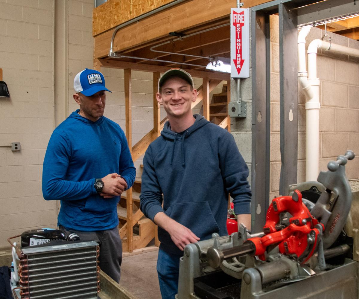 Alan G. Stanaback, a junior in heating, ventilation & air conditioning technology, shows Samir Saba the technology he employs in lab.